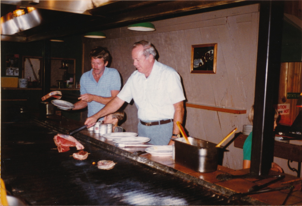 Dad and David cooking steaks