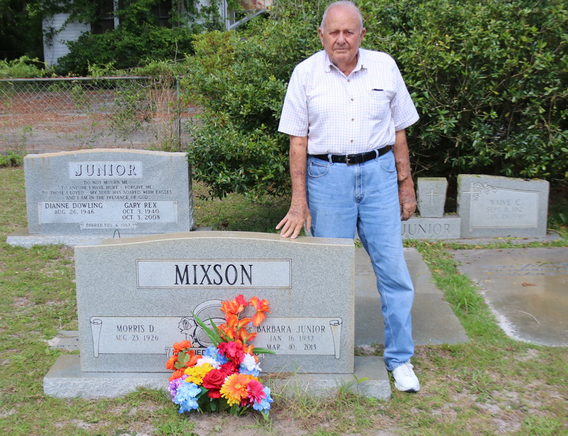 Dad putting flowers on Mom's grave